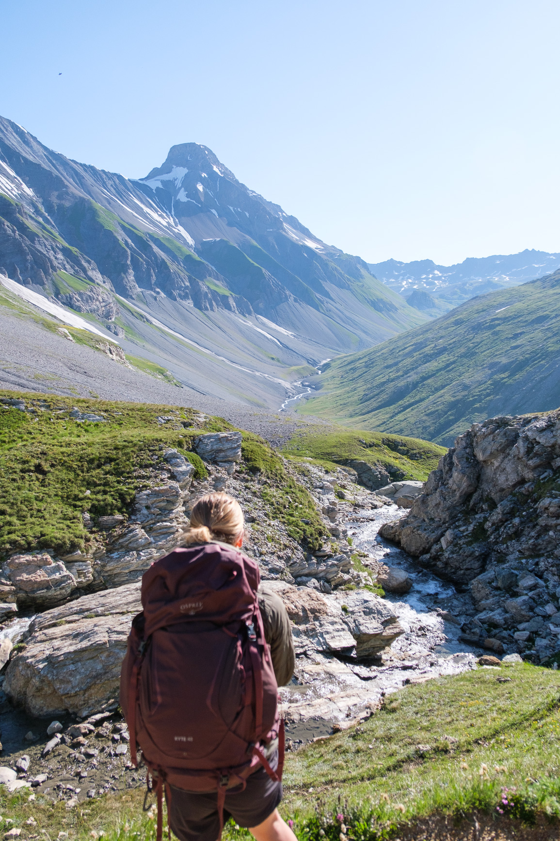 Randonneuse seule sur un sentier avec vue sur les sommets enneigés de vanoise