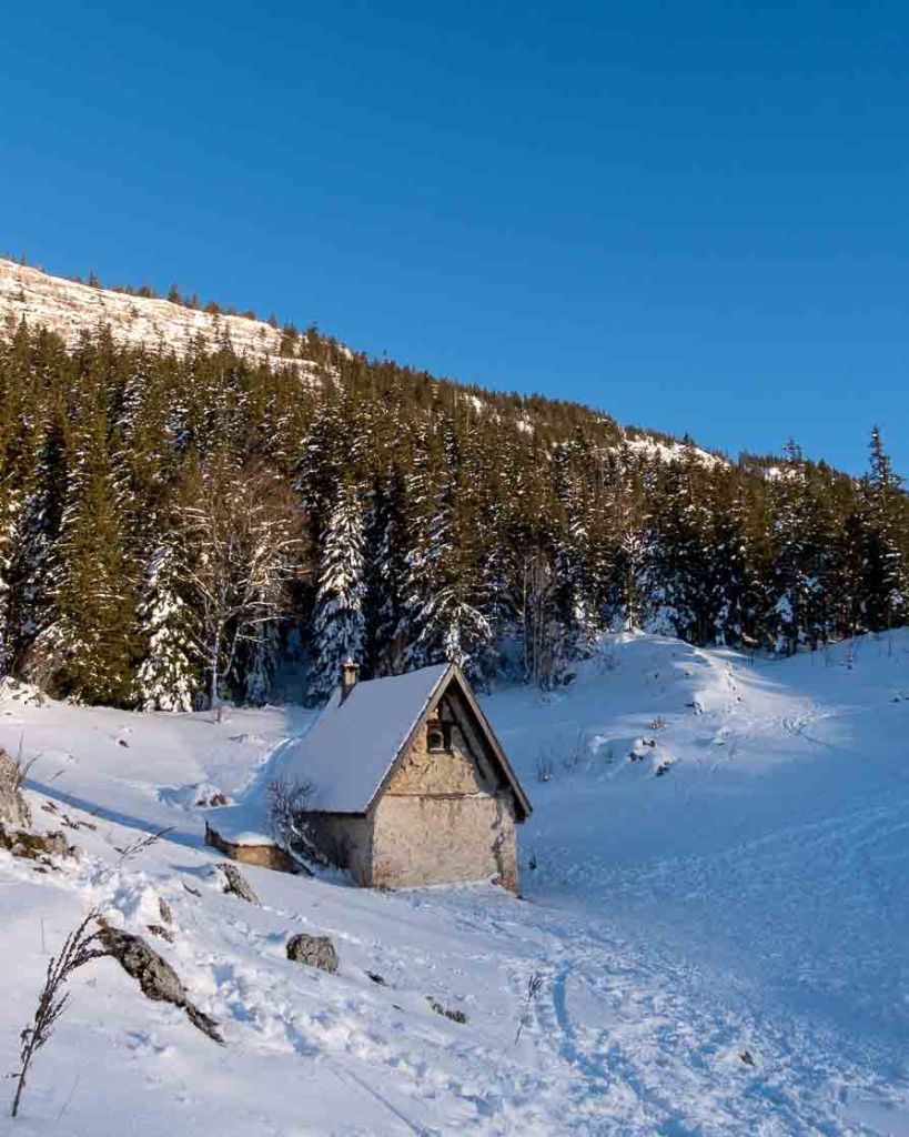 Derniers rayons du soleil d’hiver illuminant une petite cabane dans le massif du Vercors.