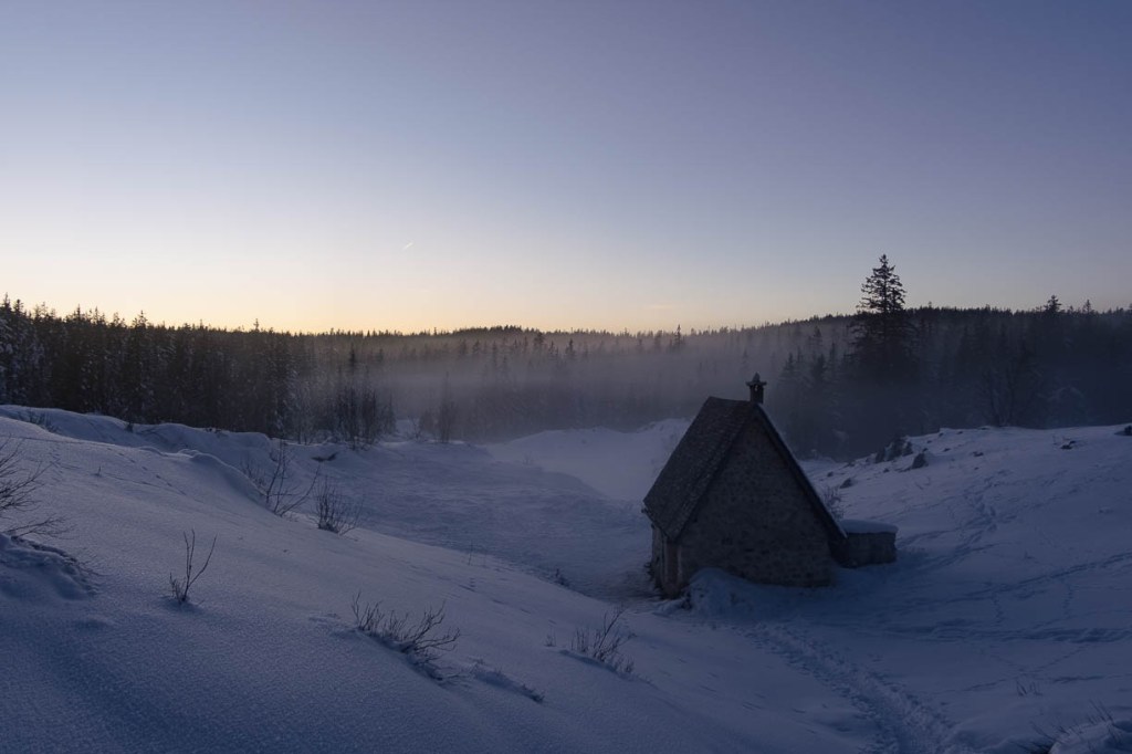 Trace de raquettes menant à une cabane de montagne isolée dans le Vercors en hiver.