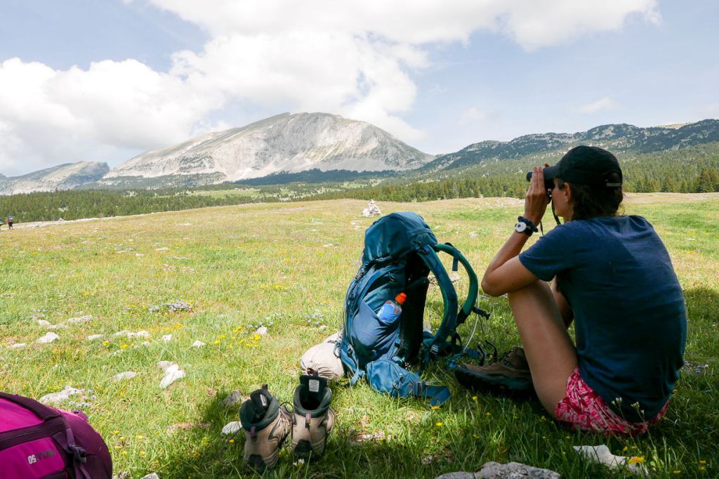 randonneuse qui observe le grand veymont à la jumelle sur les hauts plateaux du vercors